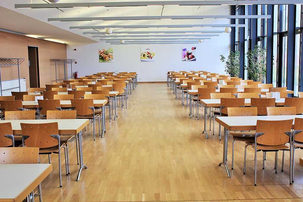 Innenansicht Mensa Speiseraum mit Tischen und Stühlen