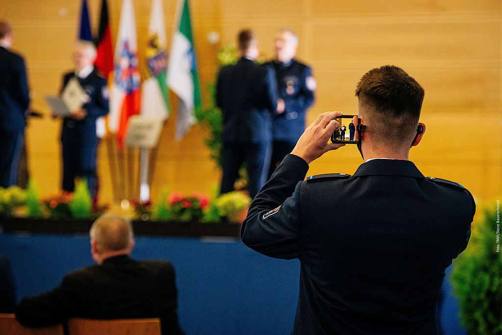 Polizeischüler macht ein Bild mit seinem Handy