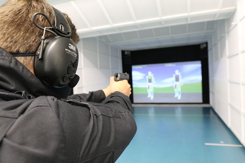 Polizist mit Waffe zielt
