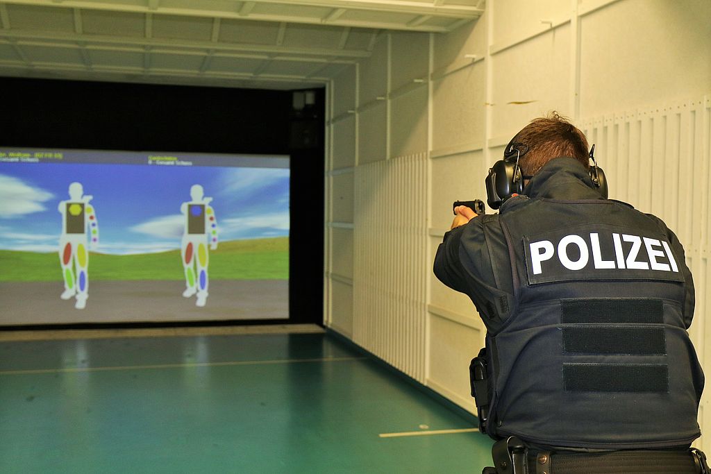 Polizist schießt auf Leinwand