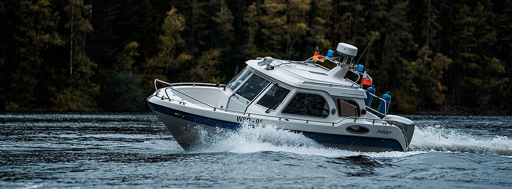 Polizeiboot fährt auf einem Stausee.
