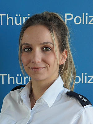 Bild zeigt: Das Portrait einer Frau mit blonden Haaren. Sie trägt eine Polizeiuniform