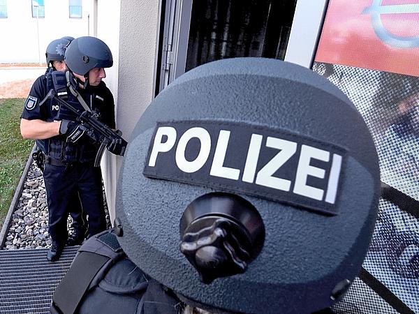 Einsatztraining drei personen, eine mit Polizeihelm