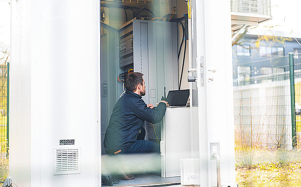 Ein Mann im Container am Digitalfunkmast beim Messen