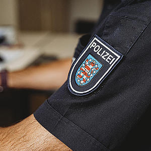Nahaufnahme des Polizeipatches. Das Patch ist auf dem Hemdärmel eines Kollegen