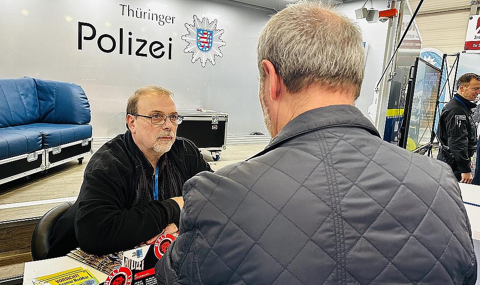 Polizist im Beratungsgespräch mit einem Bürger.