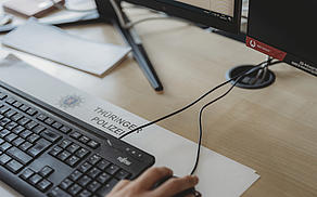 Arbeitsplatz in der KPI GTH: Man sieht Schreibblock, Tastatur und Hand