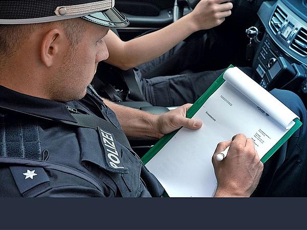 Polizeischüler notiert auf Klemmbrett