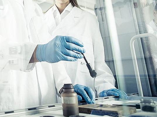 Polizeischüler mit Lehrer im Kriminaltechnik-Labor