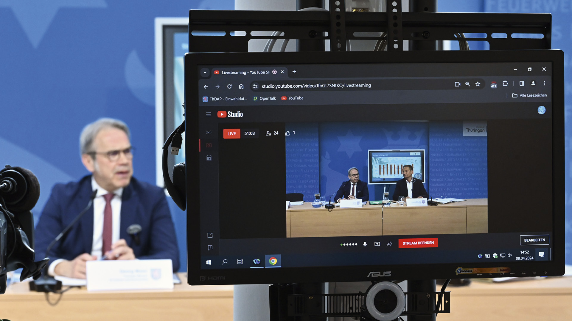 Innenminister Maier im Bild links, durch einen Bildschirmmonitor sind Herr Maier und Herr Kehr (Präsident LKA) zu sehen